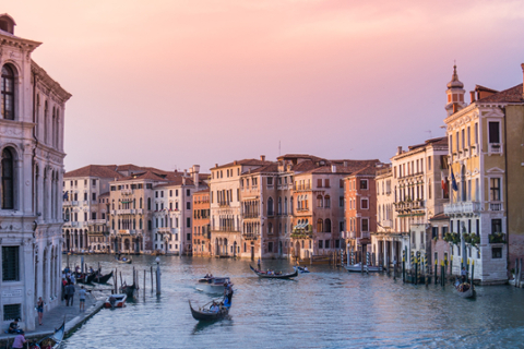 view of a large canal in Venice italy. sunrise or sunset with Gondola's in the water and buildings on each side of the canal